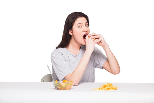 Foto de mulher com frutas e hambúrguer na frente em bac branco — Fotografia de Stock