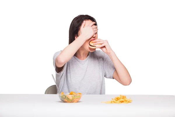 Bild einer Frau mit Früchten und Hamburger vorne auf weißem Bac — Stockfoto