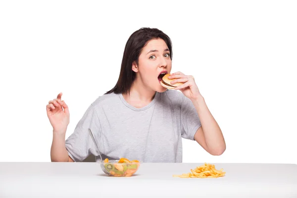 Foto di donna con frutta e hamburger davanti su bac bianco — Foto Stock