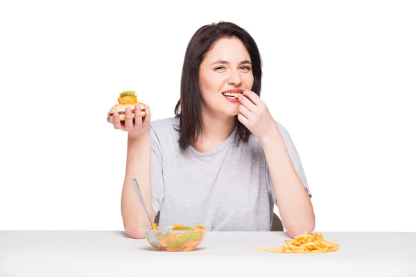 Picture of woman with fruits and hamburger in front on white bac — Stock Photo, Image