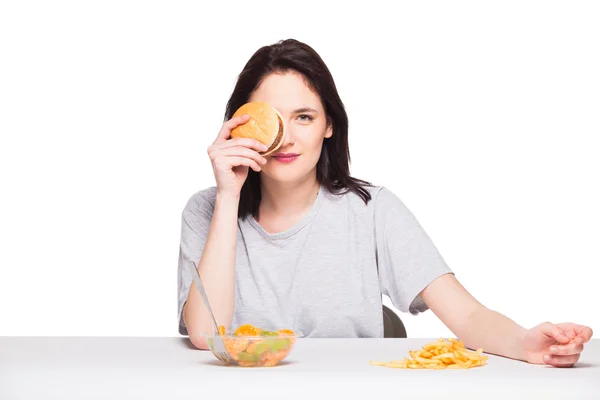 Imagen de la mujer con frutas y hamburguesa en frente en bac blanco —  Fotos de Stock