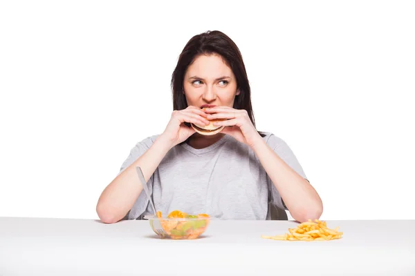 Imagen de la mujer con frutas y hamburguesa en frente en bac blanco — Foto de Stock