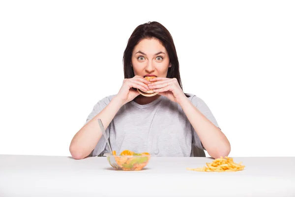 Imagen de la mujer con frutas y hamburguesa en frente en bac blanco —  Fotos de Stock