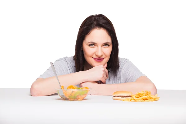 Imagen de la mujer con frutas y hamburguesa en frente en bac blanco —  Fotos de Stock