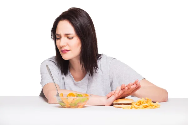 Picture of woman with fruits and hamburger in front on white bac — Stock Photo, Image