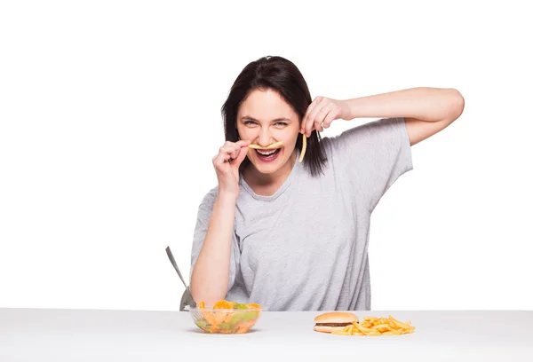 Picture of woman with fruits and hamburger in front on white bac — Stock Photo, Image