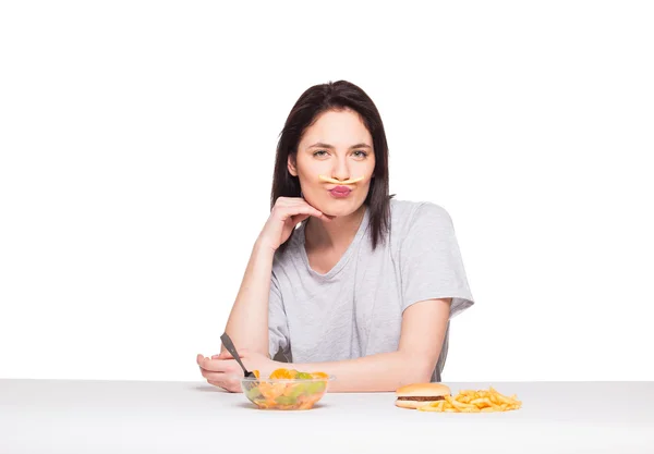 Picture of woman with fruits and hamburger in front on white bac — Stock Photo, Image