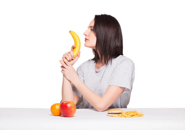 Picture of woman with fruits and hamburger in front on white bac — Stock Photo, Image