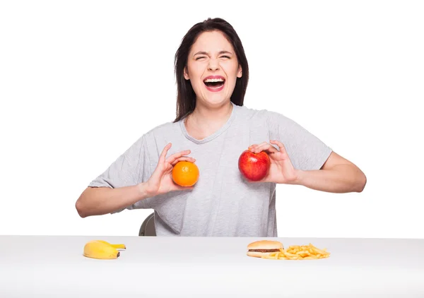 Meyve ve hamburger önünde üzerinde beyaz bac ile kadın resim — Stok fotoğraf