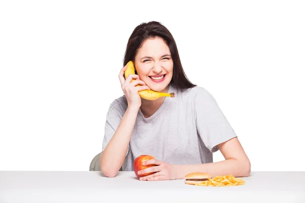 Picture of woman with fruits and hamburger in front on white bac — Stock Photo, Image