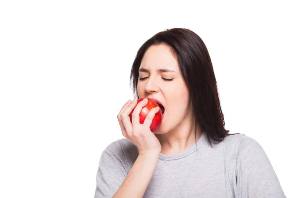 Junge Frau isst Apfel auf weißem Hintergrund — Stockfoto