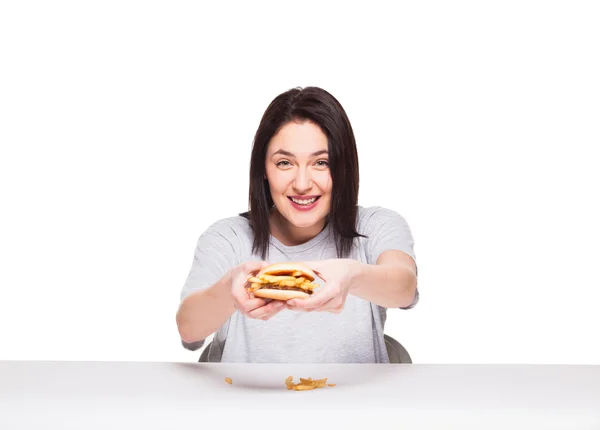 Giovane donna mangiare hamburger isolato su bianco — Foto Stock