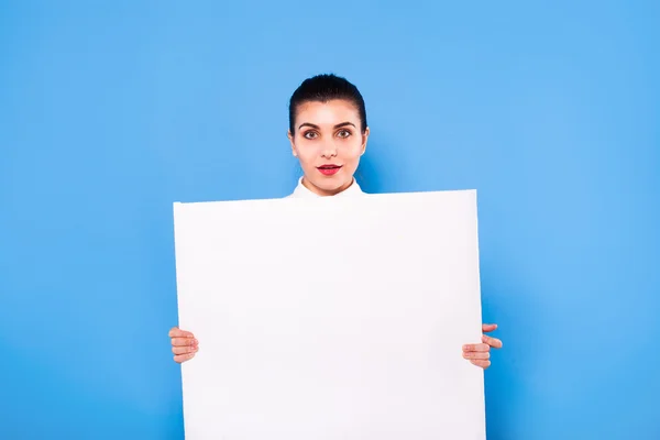 Mujer de negocios en ropa formal con panel blanco sobre fondo azul —  Fotos de Stock