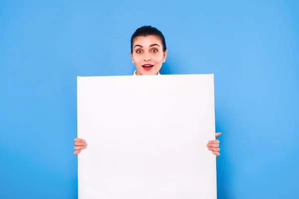 Mujer de negocios en ropa formal con panel blanco sobre fondo azul — Foto de Stock