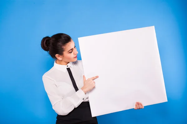 Mujer de negocios en ropa formal con panel blanco sobre fondo azul — Foto de Stock