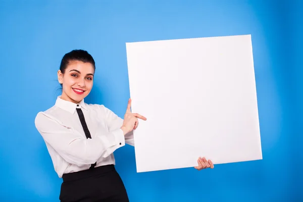 Forretningskvinde i formelt tøj med hvidt panel på blå backgroun - Stock-foto