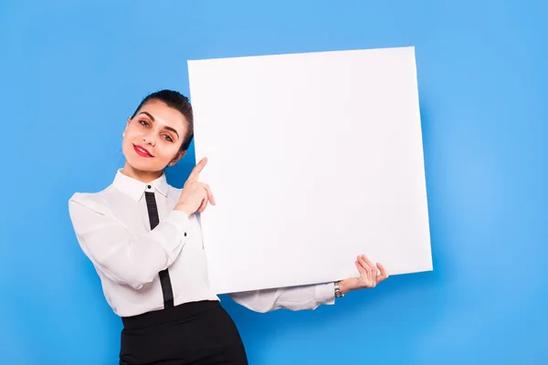 Mujer de negocios en ropa formal con panel blanco sobre fondo azul — Foto de Stock
