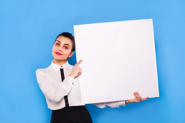 Mujer de negocios en ropa formal con panel blanco sobre fondo azul — Foto de Stock