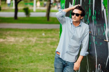 bir duvara yaslanmış cool adam