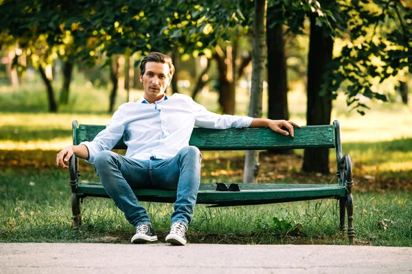 Stilig vuxen man sitter på bänken — Stockfoto