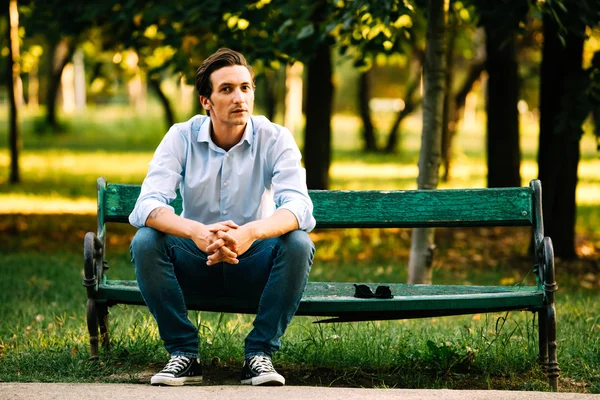 Stilig vuxen man sitter på bänken — Stockfoto