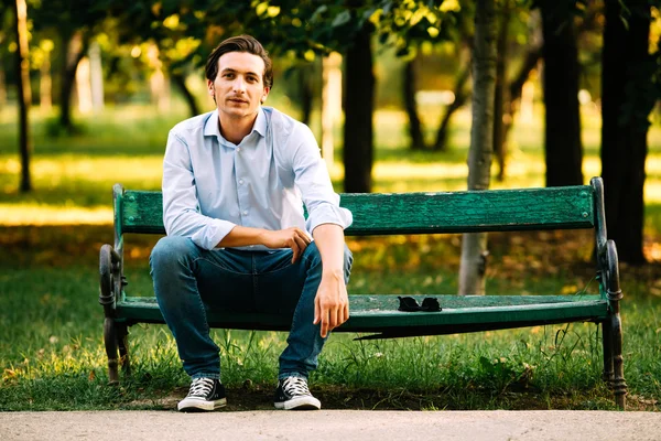 Hombre adulto guapo sentado en el banco —  Fotos de Stock