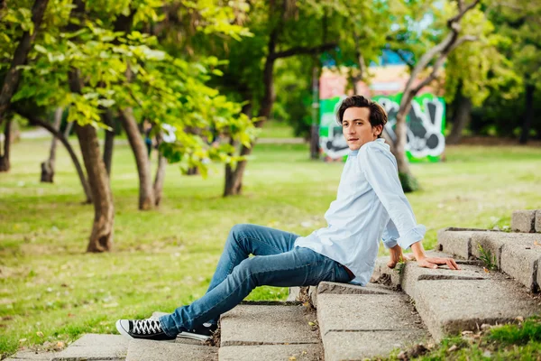Homme adulte assis sur les escaliers dans un parc — Photo