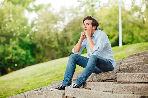 Erwachsener Mann sitzt auf Treppe in einem Park — Stockfoto