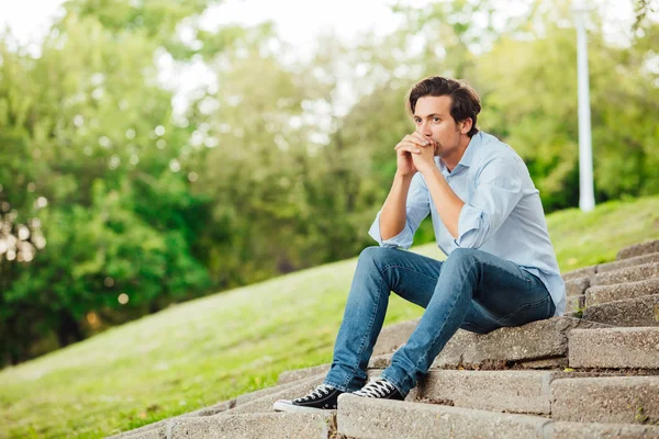 Uomo adulto seduto sulle scale in un parco — Foto Stock