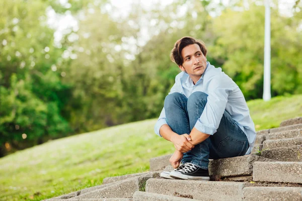 Uomo adulto seduto sulle scale in un parco — Foto Stock