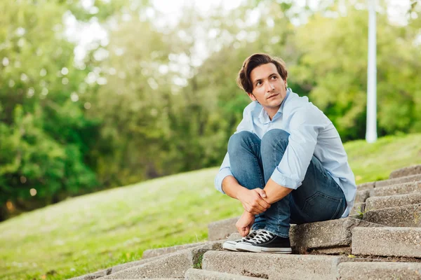 Uomo adulto seduto sulle scale in un parco — Foto Stock