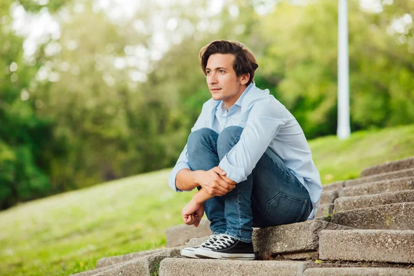 Erwachsener Mann sitzt auf Treppe in einem Park — Stockfoto
