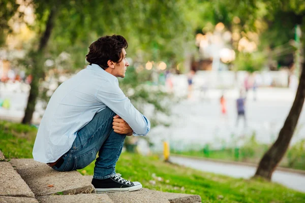 Homme adulte assis sur les escaliers dans un parc — Photo