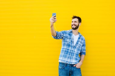 Sarı duvar kulaklıklarla yakışıklı delikanlı