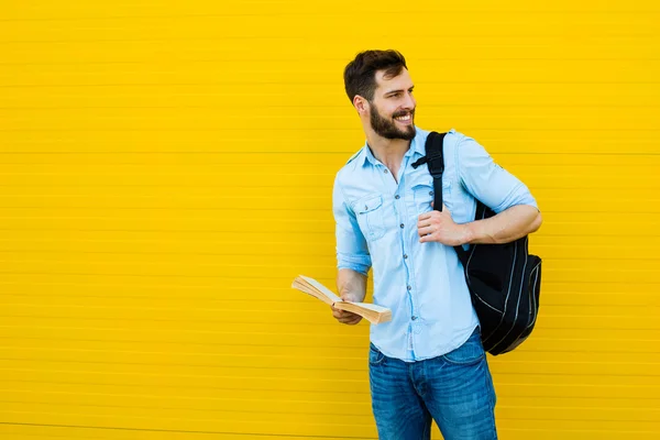 Schöner Mann mit Rucksack auf gelb — Stockfoto