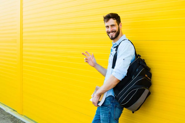 Pohledný muž s batohem na žluté — Stock fotografie