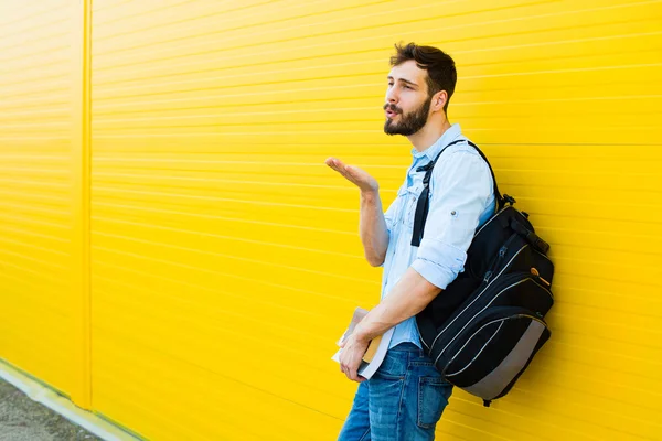 Pohledný muž s batohem na žluté — Stock fotografie