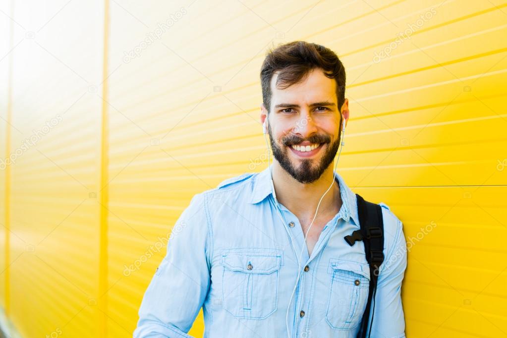 handsome man with backpack on yellow