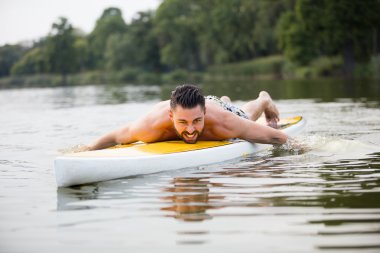 atletik erkek bir paddleboard Yüzme
