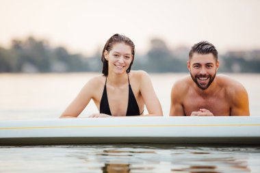 erkek ve kadın rahatlatıcı bir paddleboard su içinde