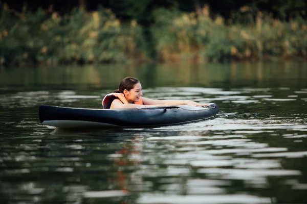 水の上のパドルボードに横たわる女 — ストック写真