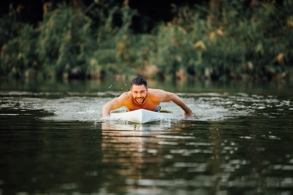 운동 남자는 paddleboard에 수영 — 스톡 사진