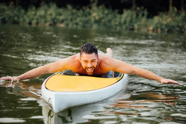 Athletic man swimming on a paddleboard — Stock Photo, Image