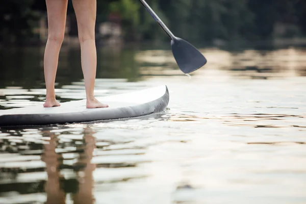 Clouse-up of a woman legs on paddleboard — Stock Photo, Image