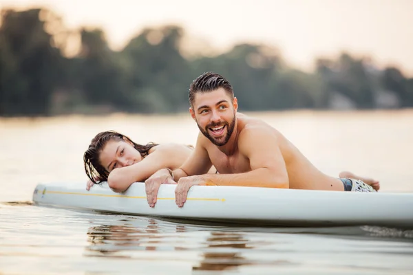 erkek ve kadın rahatlatıcı bir paddleboard su içinde