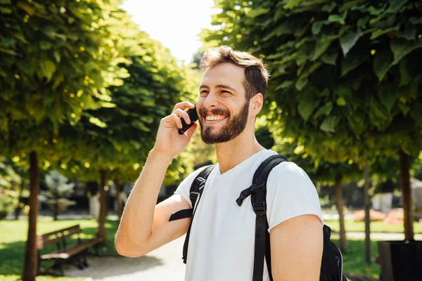 Estudante com mochila conversando no celular — Fotografia de Stock