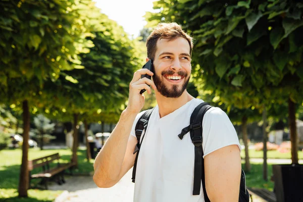 Student s batohem mluvit na mobil — Stock fotografie