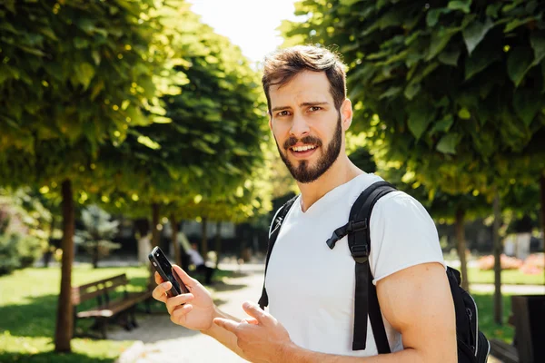 Estudiante con mochila hablando en el celular — Foto de Stock