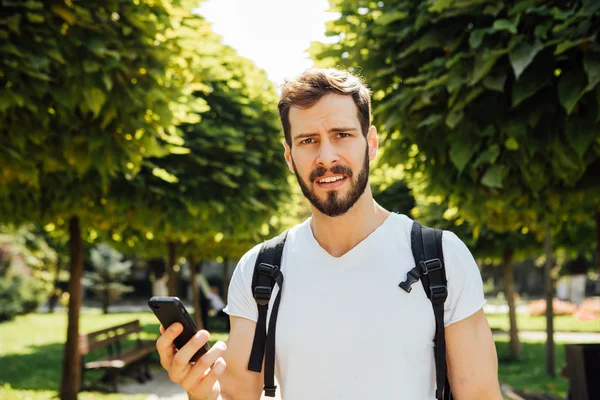 Estudiante con mochila hablando en el celular — Foto de Stock