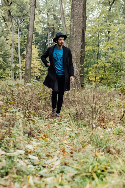 Fiatal férfi fekete kalap, erdő — Stock Fotó